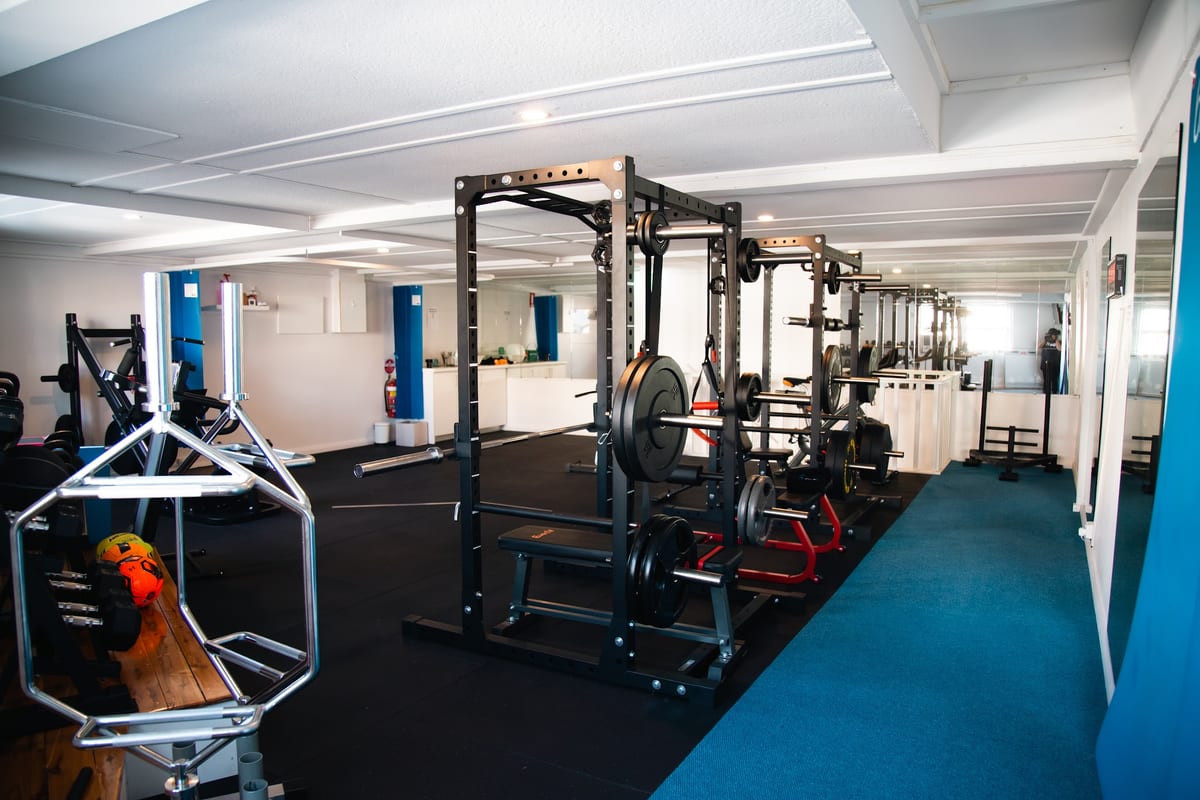 The SportsFit Five Dock gym floor with squat racks, plates, benches and cardio equipment